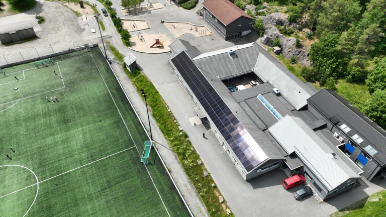 Building fitted with solar panels and a football stadium