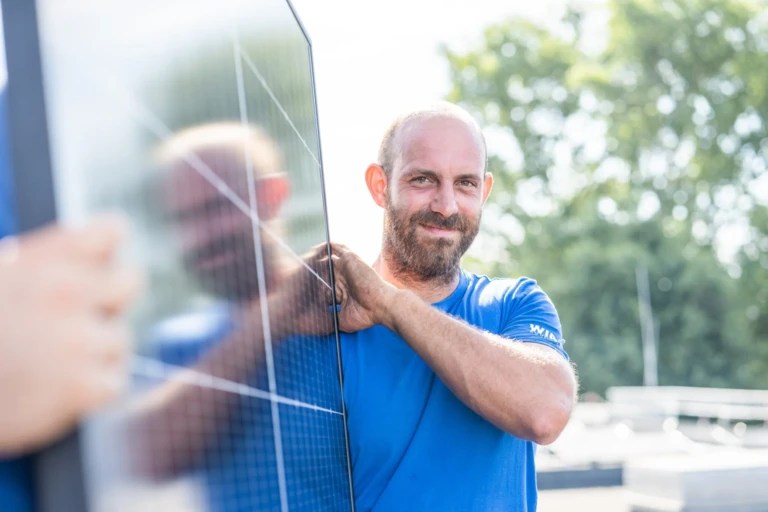 A man is carrying a solar panel